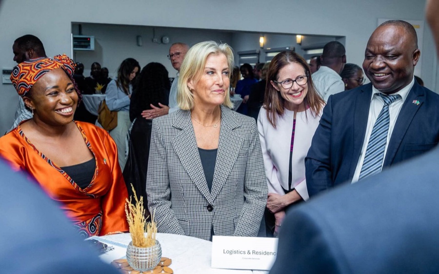 The Duchess of Edinburgh stands smiling in a group with several members of the High Commission staff