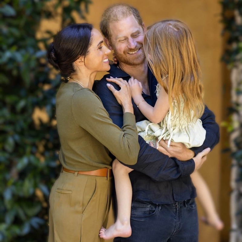 Harry og Meghan med Lilibet på armen i en klem