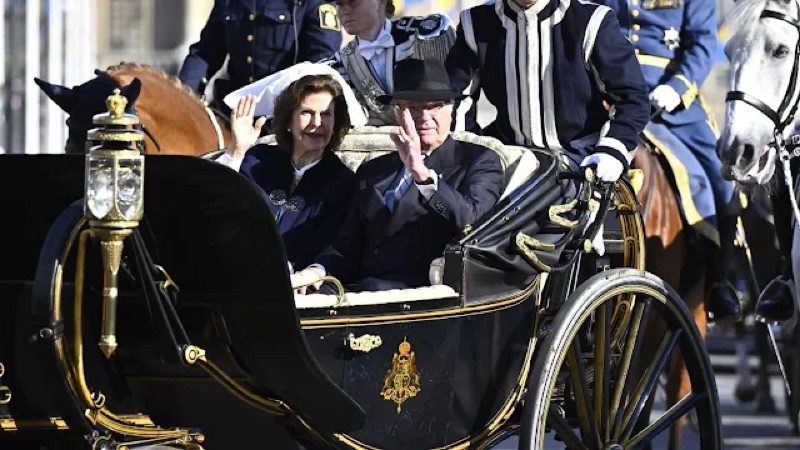 Kong Carl Gustaf og dronning Silvia i vogn under prosesjonen