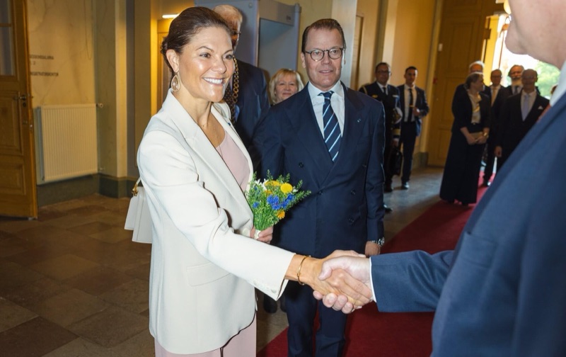 Victoria med blomsterbukett håndhilser, med Daniel ved sin side