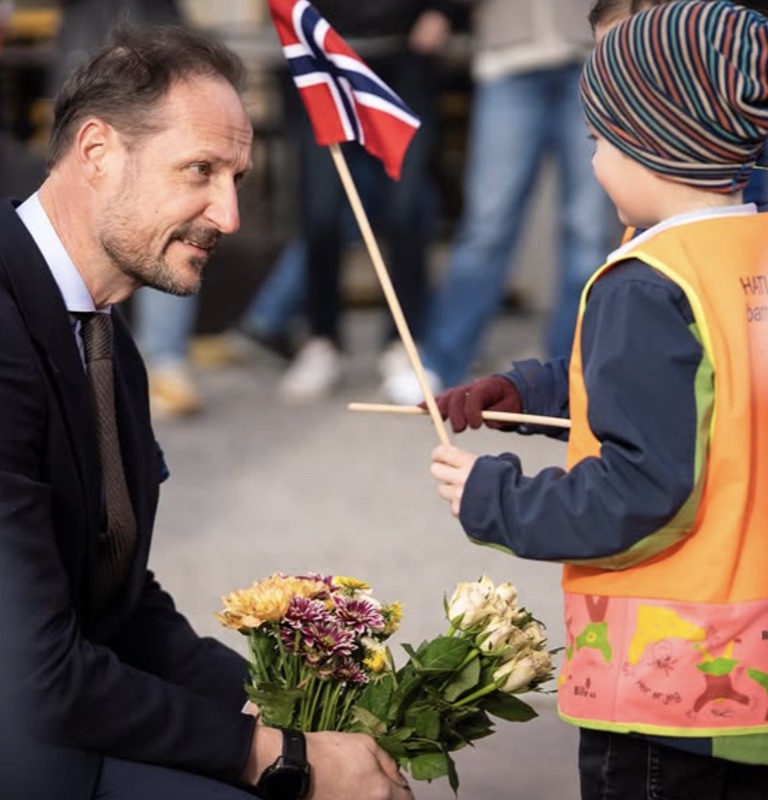 Kronprinsen møter et barn med blomster