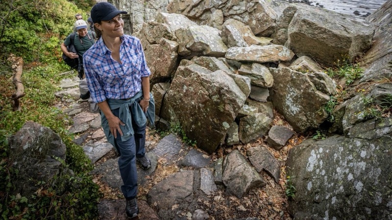 Kronprinsesse Victoria klatrer i steinete terreng ved havet