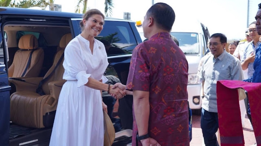 Crown Princess Victoria in a white dress greets Governor Lalu M. Iqbal beside a car on Lombok