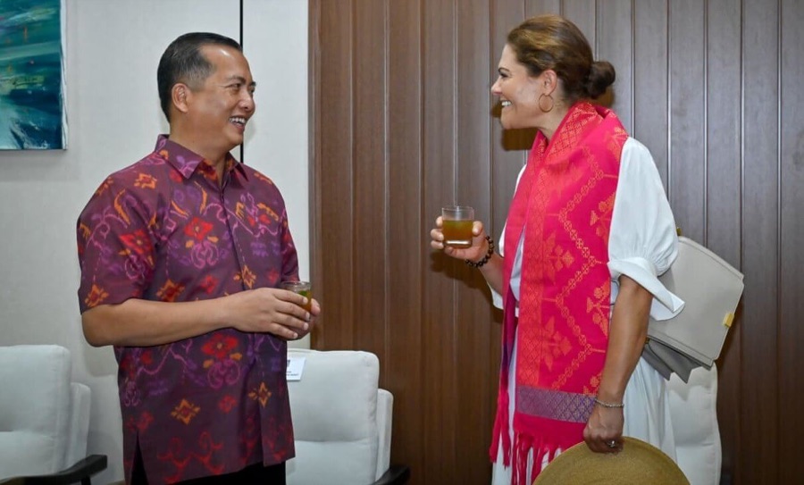 Crown Princess Victoria and Governor Lalu M. Iqbal stand talking, each holding a glass, in a meeting room