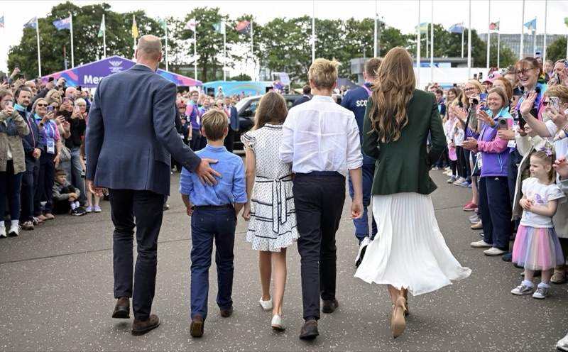 Familien Wales går gjennom folkemengden, fotografert bakfra